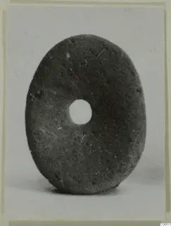 Oval disc with a central hole, a terracotta piece of jewellery.