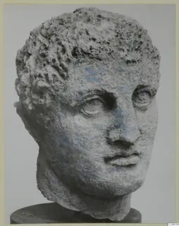 Carved limestone head with short curly hair and traces of blue paint, from Mersinaki