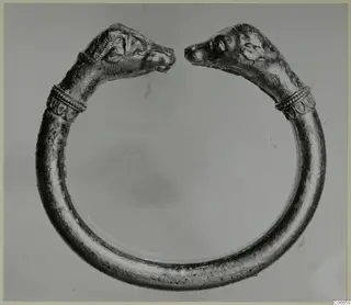 Gold penannular bracelet with animal-head terminals, the two heads facing each other across the gap.