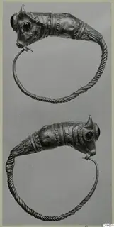 Two gold penannular rings with animal-head terminals, dark stone-set eyes and twisted wire bands