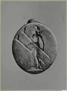 Oval gold pendant with a relief of a standing figure in profile holding a long diagonal staff