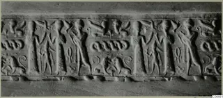 Long carved band with rows of standing figures, paired animals with curled tails and small looped motifs, seen from the front.
