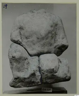 Limestone sculpture fragment from Mersinaki, several pieces fitted together, standing on a wooden base