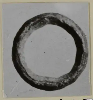 Bronze ring-shaped personal adornment, seen from above against a pale background