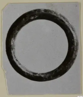Bronze ring-shaped personal adornment, a thick dark circlet on a light ground