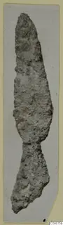 Corroded bronze weapon from Soli with a pointed tip and a broken lower end, shown upright.