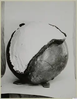 Pottery jug with a large white filler covering its upper part, with two loose sherds at its base