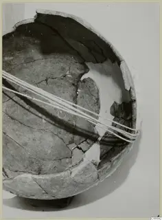 Reconstructed Red Polished II jug, made of broken sherds bound together with white cord, shown against a pale background.