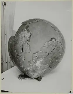 Red Polished II jug, reconstructed from broken fragments, shown on a pale surface