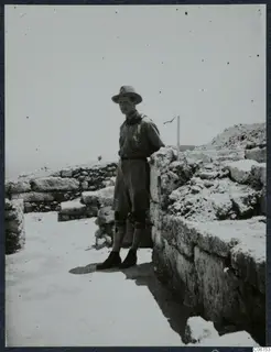 Einar Gjerstad standing beside a stone wall among ruined stonework at Vouni.
