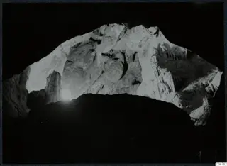 Interior view through a cave opening at Kythrea, with pale rock walls and hanging rock formations