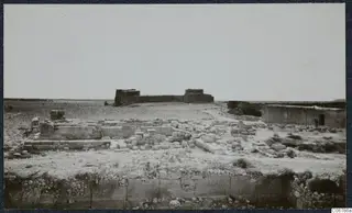 Ruins of the Temple of Aphrodite at Kouklia: low stone walls and scattered blocks on flat, stony ground.
