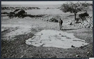 Mosaic floor at the ruins of the Temple of Aphrodite, Kouklia, with a man in a suit standing beside it.
