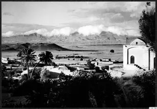 View over low buildings and palm trees toward a broad plain and mountains at Nicosia