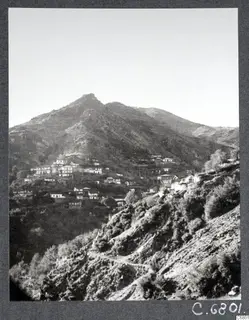 View of the village of Pedoulas in the Troodos Mountains, houses on a hillside below a mountain peak
