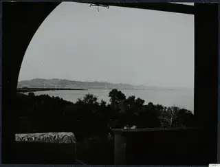 View through an archway over dark trees and sea towards distant hills at Salamis, Famagusta