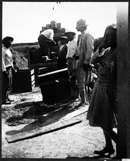 Workers loading wooden boxes onto a cart at Ayios Iakovos