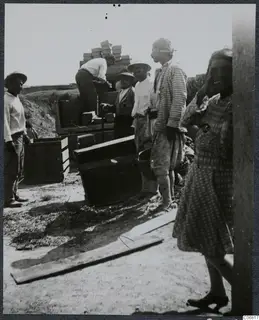 Workers loading wooden crates onto a cart at Ayios Iakovos