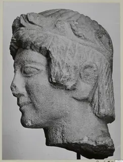 Limestone bust from Mersinaki, shown in profile facing left, with a ridged hairstyle and a broken base.