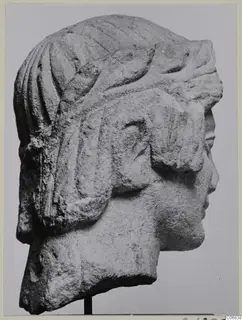 Limestone head in right profile from Mersinaki, with ridged locks of hair and carved bands across the top of the head.