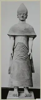 Terracotta statue of a standing figure with a pointed headdress and incised cape, from Ayia Irini