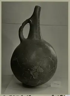 Pottery Red Polished I vessel from Lapithos with a globular body, tall neck and loop handle