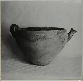 Pottery Red Polished III bowl with a loop handle on the left and a short spout on the right, shown from the side