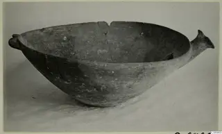 Pottery Red Polished III bowl, deep and rounded, with a knob-like lug on the left rim and a horn-shaped handle on the right.