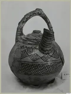 Painted pottery jug with a strap handle and tall spout, decorated with dark bands, zigzags and cross-hatching