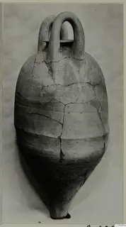 Pottery vessel with two loop handles and a pointed base, cracked and joined, against a pale background