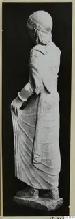 Limestone statue of a standing woman from Vouni, shown from the side and slightly from behind