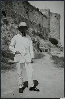 Alfred Westholm in a white suit and pith helmet standing beside the fortress wall at Kyrenia.