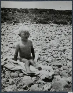 Stefan Gjerstad, a small child sitting on a blanket among rounded stones