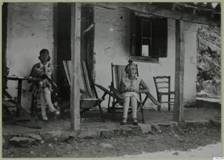 Vivi Gjerstad and Gudrun Atterman seated on the veranda of a whitewashed building at Machairas