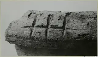 Fragment of a thick pottery vessel wall with incised vertical and horizontal signs on its outer surface