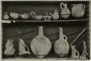 Pottery jars and bowls from T.7 at Lapithos Markides, set out on two shelves.