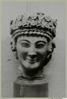 Limestone head fragment from Vouni, with a high headdress of raised leaf-like ornament and a smiling face