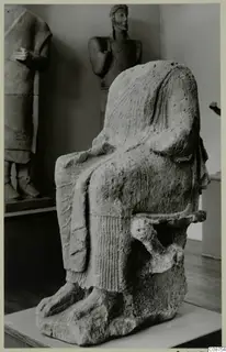 Neo-Cypriote limestone statue of a seated figure in a chair, photographed in a museum gallery