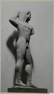 Limestone statue of a standing nude male from Kition, one arm raised to the head.