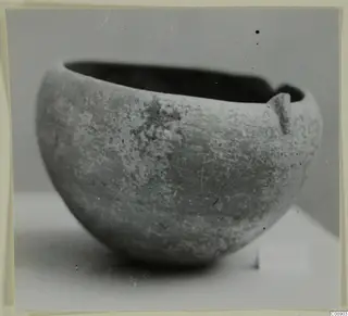 Red Polished I bowl with a small lug on the rim, photographed against a plain grey backdrop