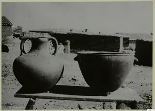 Two new pottery vessels on a wooden table in a village yard, Klirou