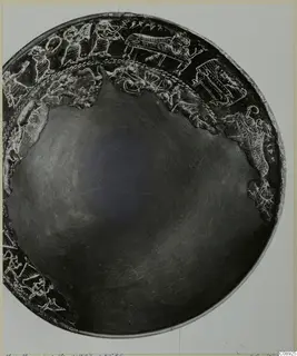 Dark bowl viewed from above, with a band of raised figures and animals in relief around its rim.