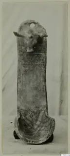 Terracotta object with a modelled animal head with horns at the top and geometric patterns on its tall body