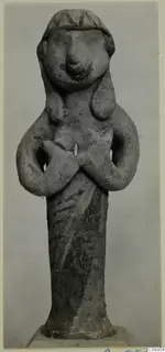 Terracotta figurine of a standing figure with arms crossed at the chest, with a patterned headdress band