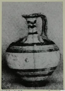 White Painted I jug with a single strap handle and dark painted bands on the body