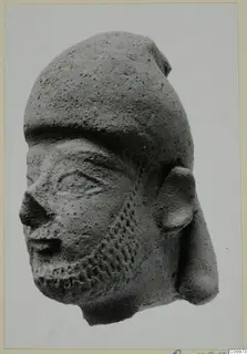 Terracotta Neo-Cypriote head with a dotted beard and a tall, rounded cap, shown in three-quarter view.