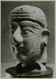 Terracotta head of a bearded man with a ridged band across the forehead, on a wooden stand