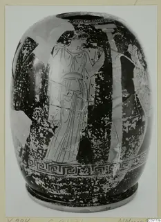 Red figured ware vessel with a standing figure in a long robe, a band of interlocking spirals below, on a card mount