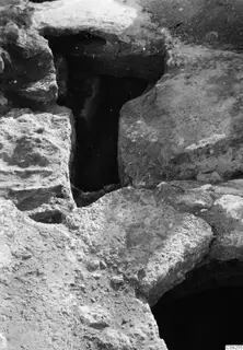 Excavated stone-lined opening at the palace at Vouni, with large blocks around a dark recess