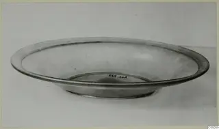 Blown glass bowl with a wide flat rim, shown on a plain surface.